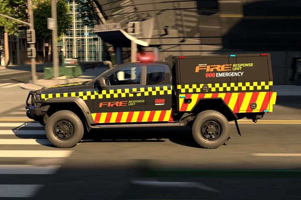Ford Ranger pickup truck modified as fire response unit, featuring high-visibility yellow and red chevron striping, parked on urban street with buildings in background