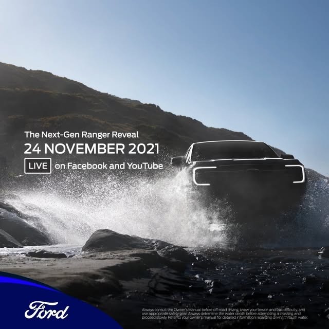 Dark silhouetted pickup truck driving through ocean waves with water spray, mountainous coastline backdrop, announcement text overlay for November 24, 2021 reveal